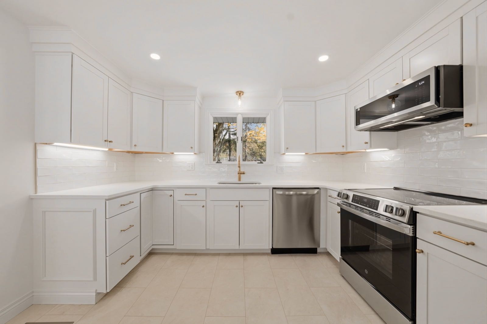 Fully renovated white kitchen with gold hardware by Homeview